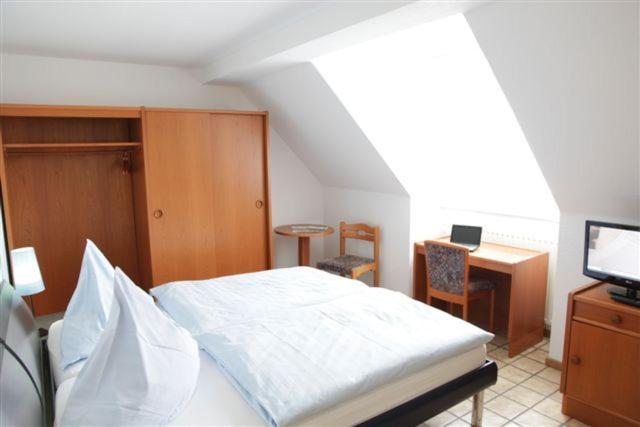 1 dormitorio con cama, escritorio y ordenador en Breer S Hotel, en Schwerte