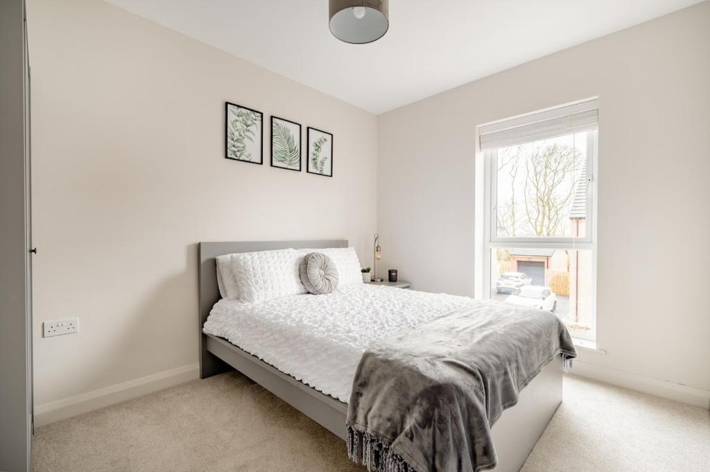 a white bedroom with a bed and a window at Double Room in Luxury High Trees Development in Donaghadee