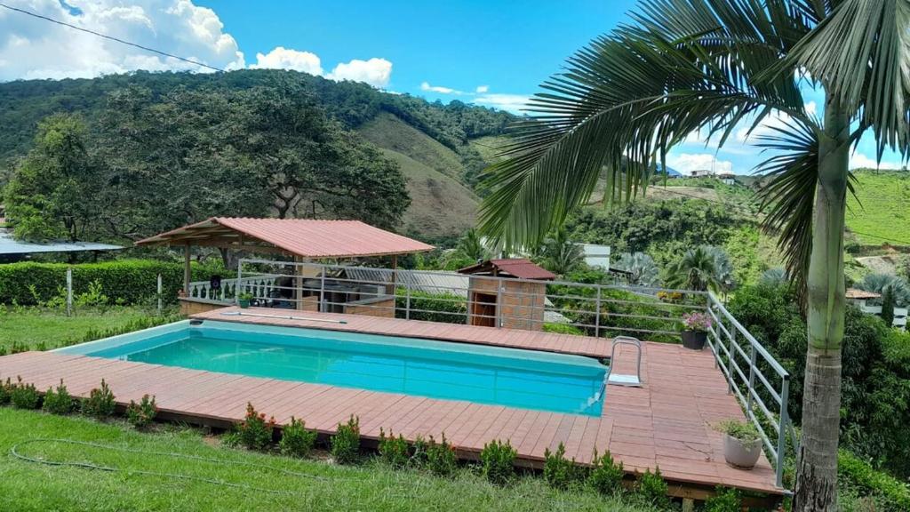 a house with a swimming pool and a palm tree at Hermosa Casa de campo cerca a Yolombo, las partidas in Yolombó