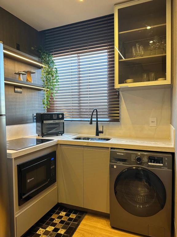 a kitchen with a sink and a washing machine at Anmu experiencie in Montes Claros