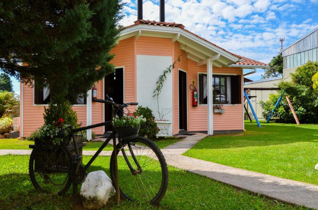 una bicicleta estacionada frente a una casa en Pousada Gramadense, en Gramado