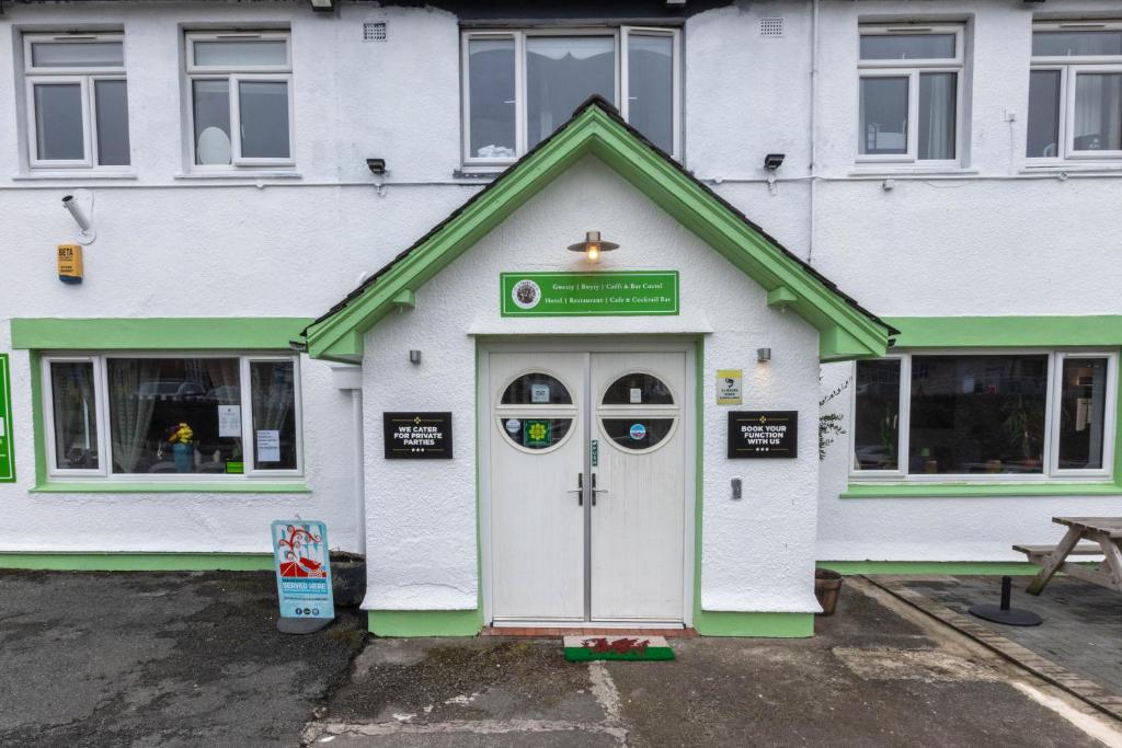 a white and green building with a door at Ty glyndwr Hotel in Bangor