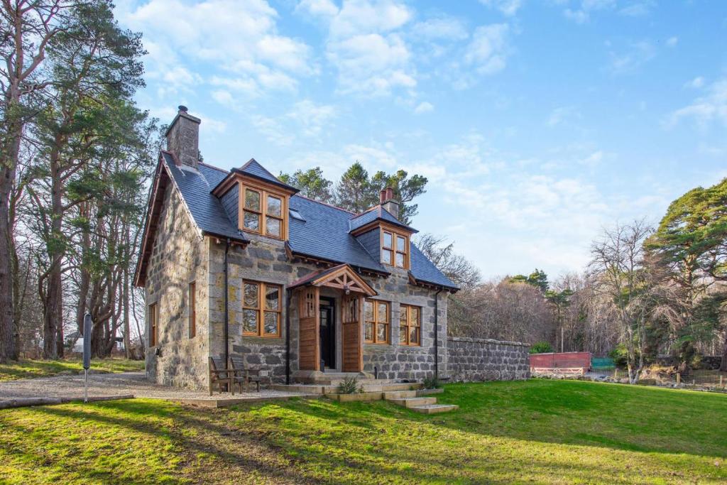 a small stone house with a blue roof at Gardeners Cottage at Craighead in Huntly
