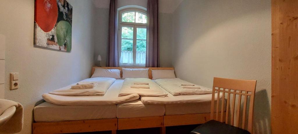 ミュンジンゲンにあるÜbernachten im Münsinger "Albgut" - Hotelzimmer, Ferienwohnungen und Stubenの窓のある部屋にある小さなベッド
