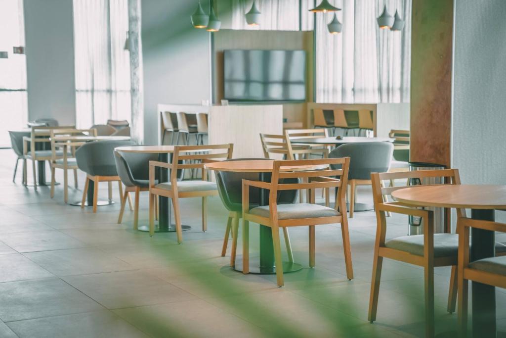 a row of tables and chairs in a restaurant at Crowne Plaza Merida by IHG in Mérida