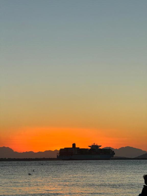 a large ship in the water at sunset at Recanto do Sol in Paranaguá