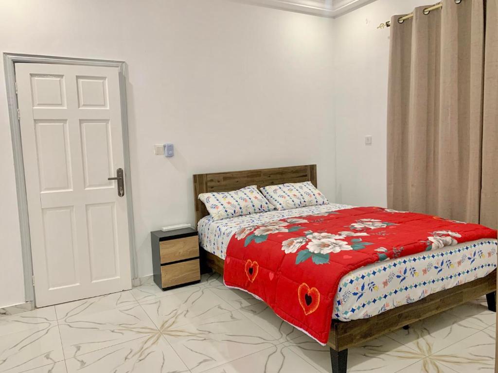 a bedroom with a bed with a red blanket at Tile House Apartments Gunjur Kolkoch in Gunjur