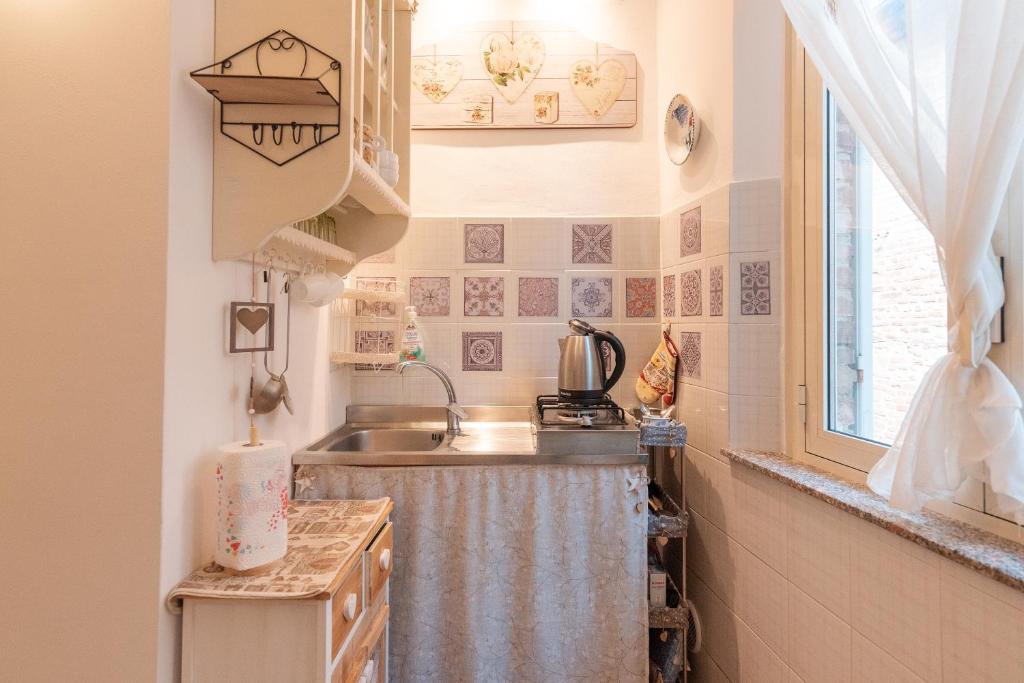 a small kitchen with a sink and a window at Il Nido del Vicolo delle scuole Pie in Città della Pieve
