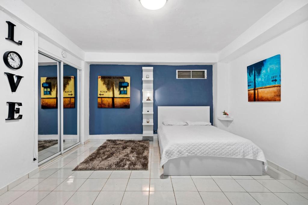 a bedroom with blue walls and a white bed at Swimming Pool Pet Welcoming Close To The Shore in San Juan