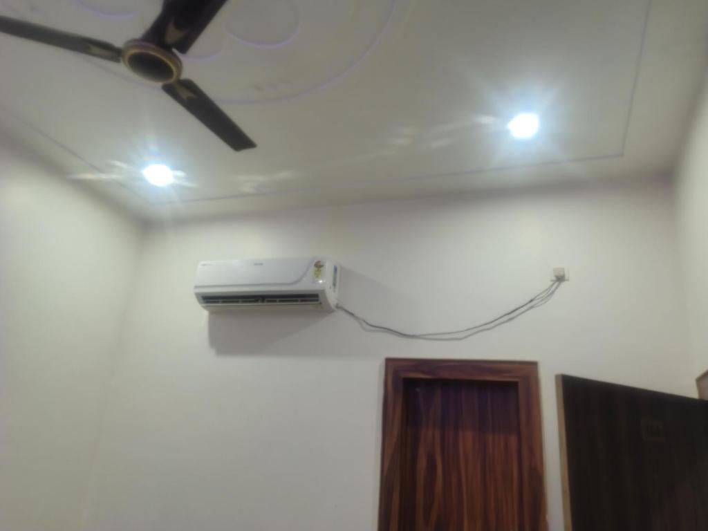 a projector on the ceiling of a room with a door at Sri LADLI restaurant in Govardhan