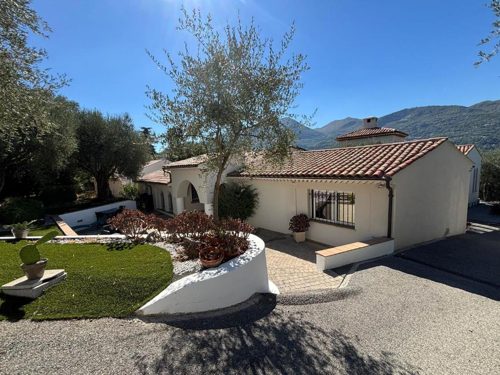 una piccola casa bianca con un albero in cortile di Escapade entre Mer et Montagnes a Saint-Martin-du-Var