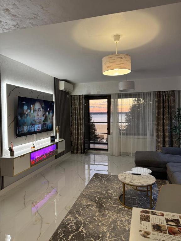 een woonkamer met een bank en een tv bij Elegance Apartament in Mamaia