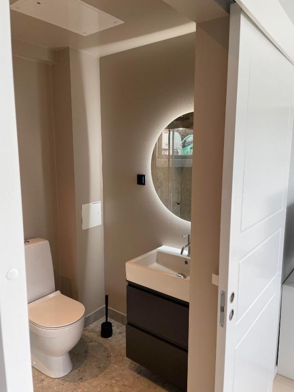 a bathroom with a toilet and a sink and a mirror at Apartment - Sleeps 3 & Great Location in Sollentuna