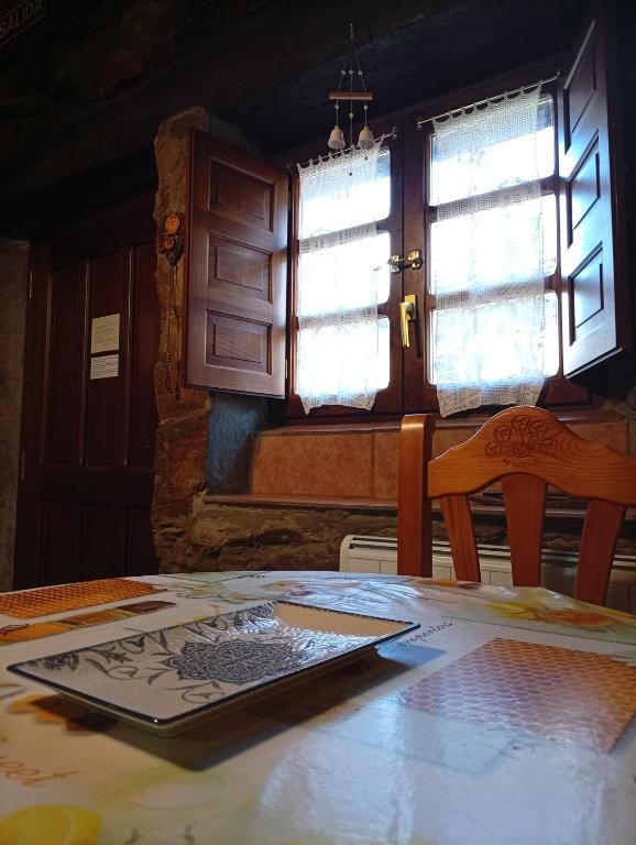 a table with a picture on it in a room with windows at Casa de Abril 1 in San Cristóbal de Valdueza