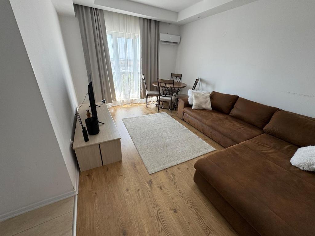 a living room with a brown couch and a table at Blue Oasis in Ştefăneştii de Sus