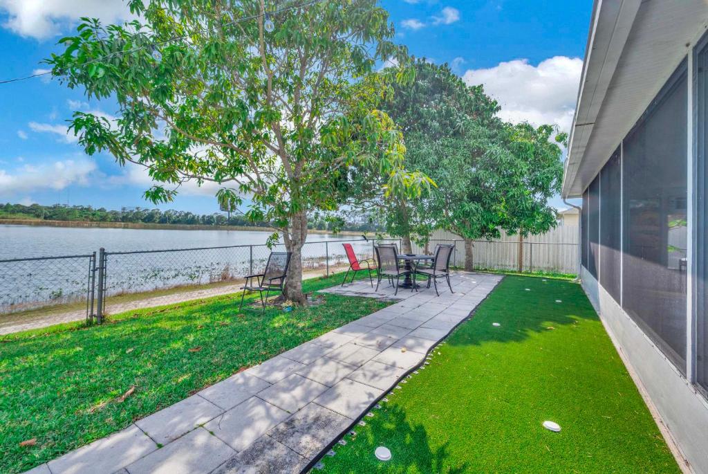 CanaOutdoor Relaxation! Port St Lucie Family Home的有桌子、椅子和一棵树的露台