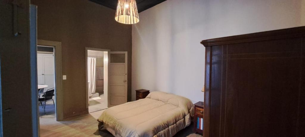 a bedroom with a bed and a room with a table at La Casona in Balcarce