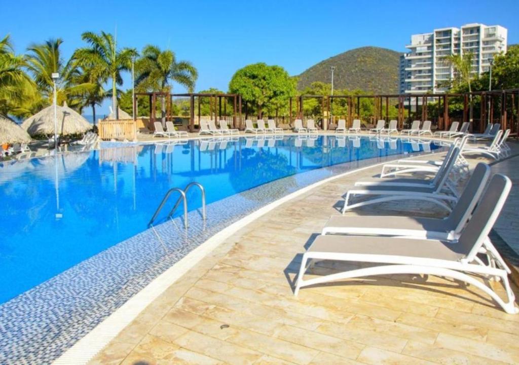 una piscina con sedie a sdraio in un resort di Samaria Club de Playa - Pozos Colorados - By INMOBILIARIA VS a Santa Marta