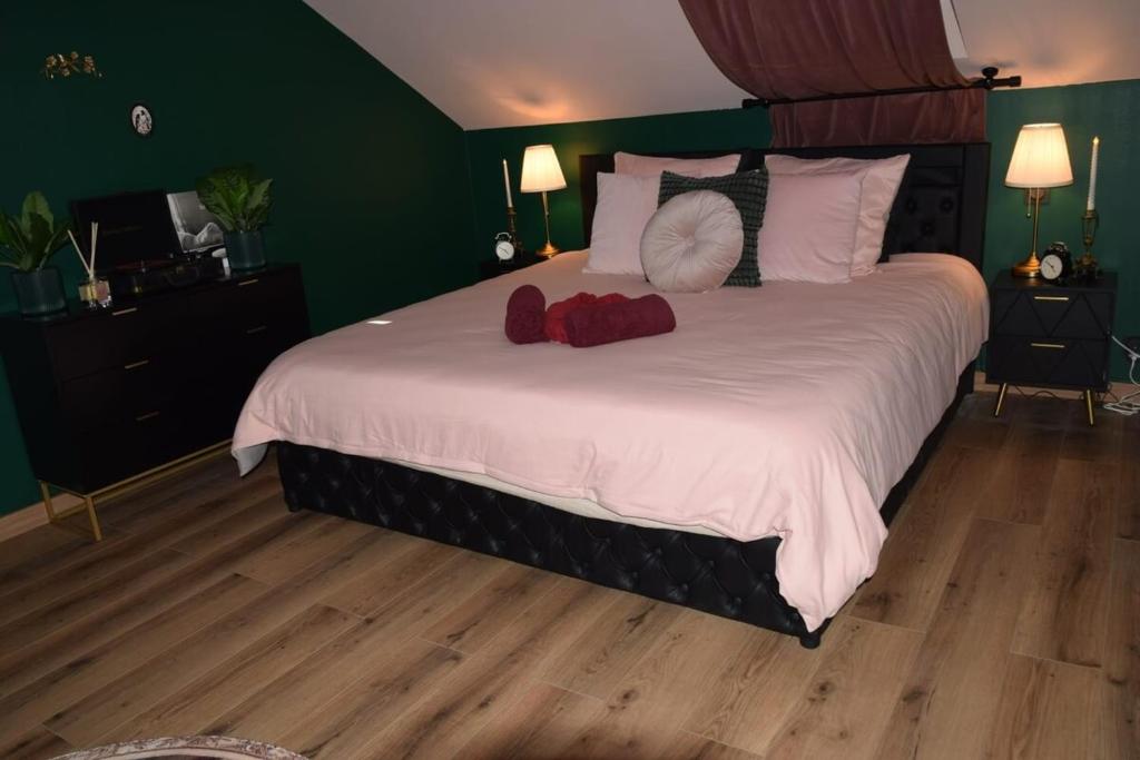 a bedroom with a large bed with two stuffed animals on it at La Bulle de Velour in Bouguenais