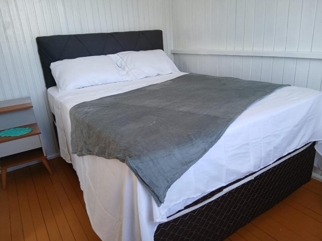 a large bed in a room with a white bedspread at Casa Mar2 in Balneário Gaivotas
