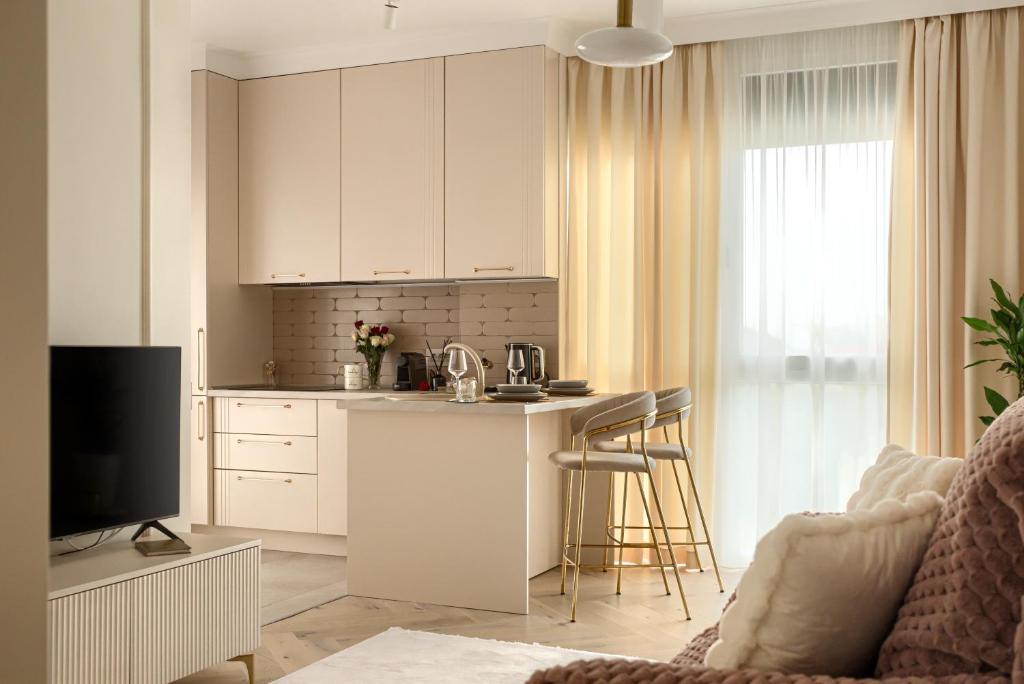 a kitchen with white cabinets and a kitchen island at ARI Luxury Apartment with Balcony in Arad