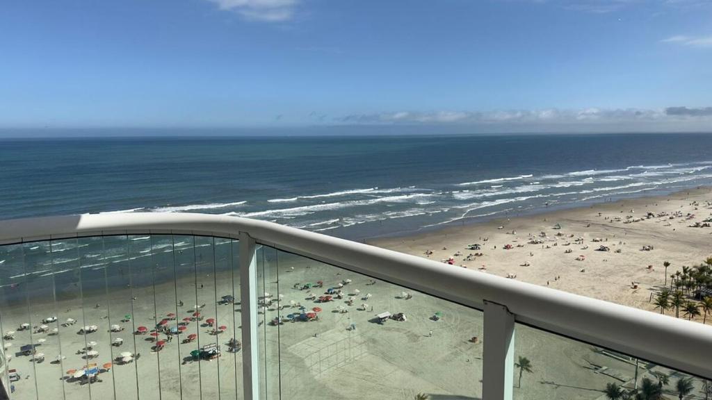 a view of the beach from a balcony of a beach at Apartamento com Prédio Frente Mar in Praia Grande