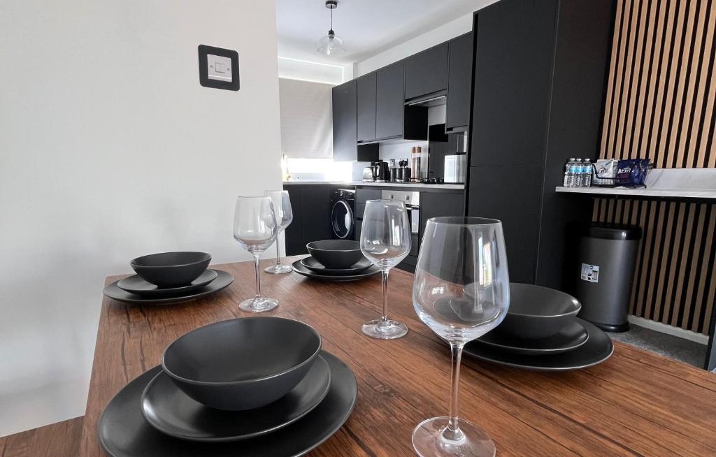 a wooden table with wine glasses and plates on it at 2 bed house in city centre - offers for long stays in Nottingham