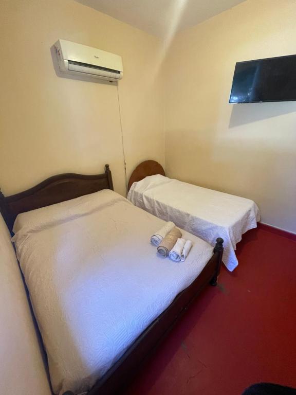 two beds in a small room with a air conditioner at La Casona in Posadas