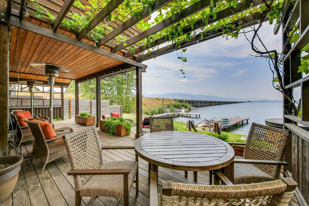 a patio with a table and chairs and a view of the water at Lake Pend Oreille Oasis Home with Hot Tub and Games in Sagle