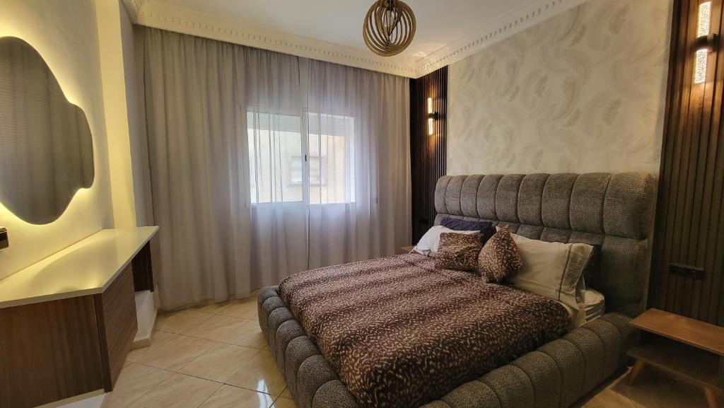 a bedroom with a bed and a window at Résidence jawharat mogador in Essaouira