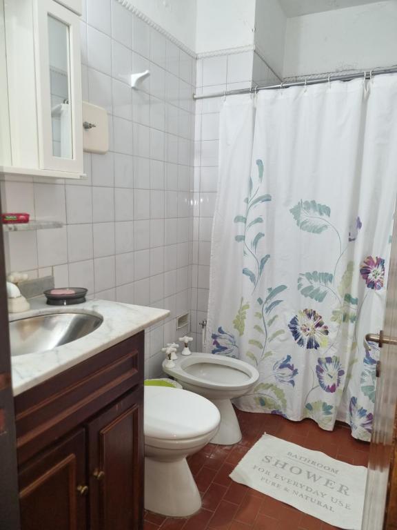 un bagno con un water e una tenda da doccia di DEPARTAMENTO CENTRICO ALAUAL a Concordia