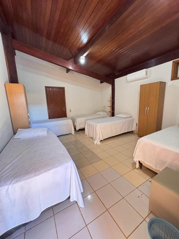 a room with three beds and a tiled floor at Hotel pousada Janaúba in Janaúba