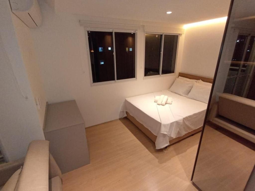Un dormitorio pequeño con una cama y una ventana. en Studio Moderno Completo Ar cond Porto Maravilha RJ, en Río de Janeiro