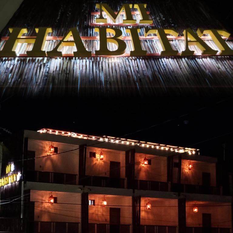 a building with a neon sign on top of it at Mi habitat holbox-Maravilla natural in Holbox Island