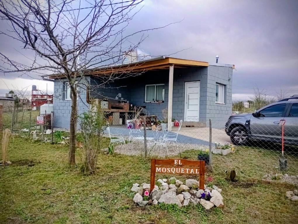 a house with a sign in front of it at Elmosquetal in Villa Yacanto