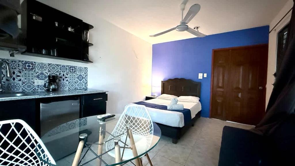 a hotel room with a bed and a table and chairs at Cozy Apartment for 2 with Pool Access in Chuburná de Hidalgo