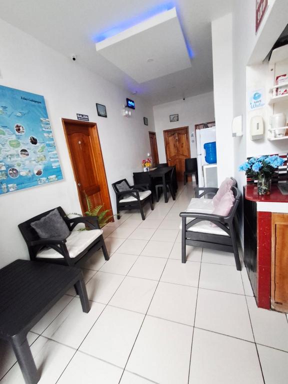 a living room with chairs and a dining room at Hostal Marysol in Puerto Ayora