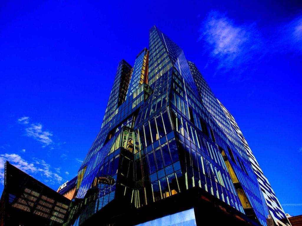 a tall glass building against a blue sky at Swissotel Sarajevo in Sarajevo