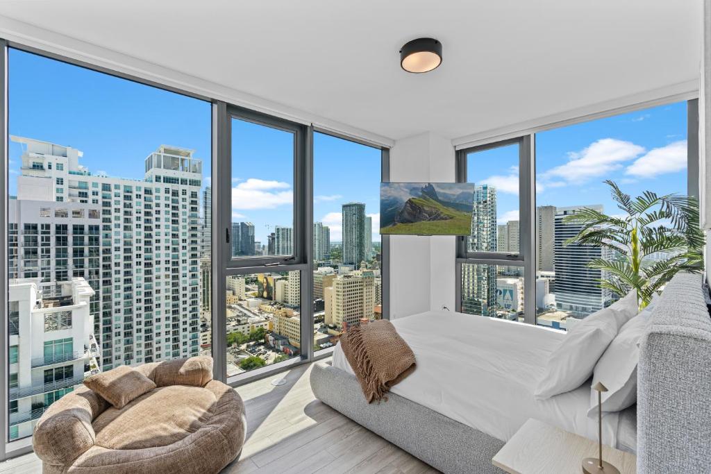 Una habitación con grandes ventanales con una cama y un sofá. en Downtown Miami Luxury Two Bed Two Bath, en Miami