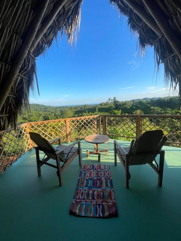 une vue depuis la terrasse d'un complexe hôtelier avec des chaises et une table dans l'établissement Casa Akasha, à Mingueo