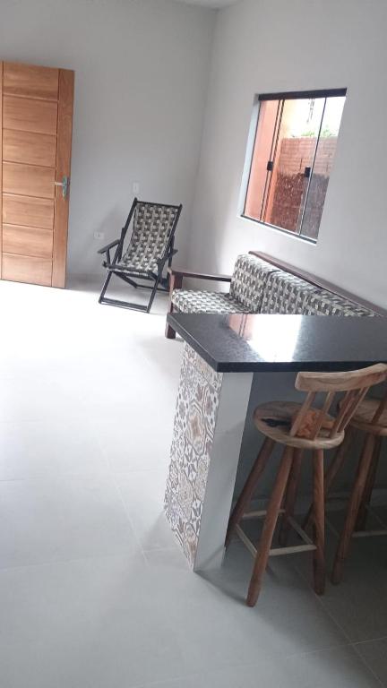un bancone nero con uno sgabello di legno e un tavolo di J&M Ubatuba a Ubatuba