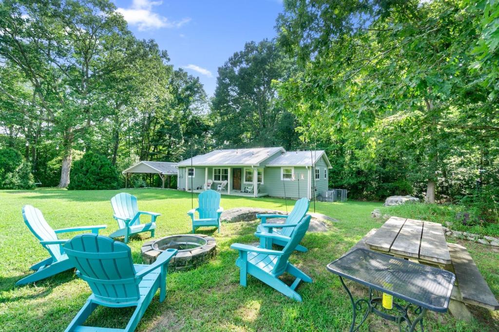 een groep stoelen rond een vuurplaats in een tuin bij Pennington Place Lookout Mtn in Rising Fawn