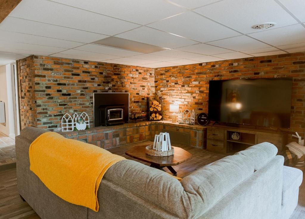 a living room with a couch and a flat screen tv at Terrace Lodge 2 bedroom apt with private indoor pool and forest views in Clarion