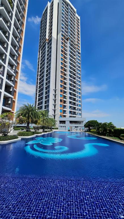 a large swimming pool in front of two tall buildings at Artisan Ratchada Condo Bangkok in Bangkok