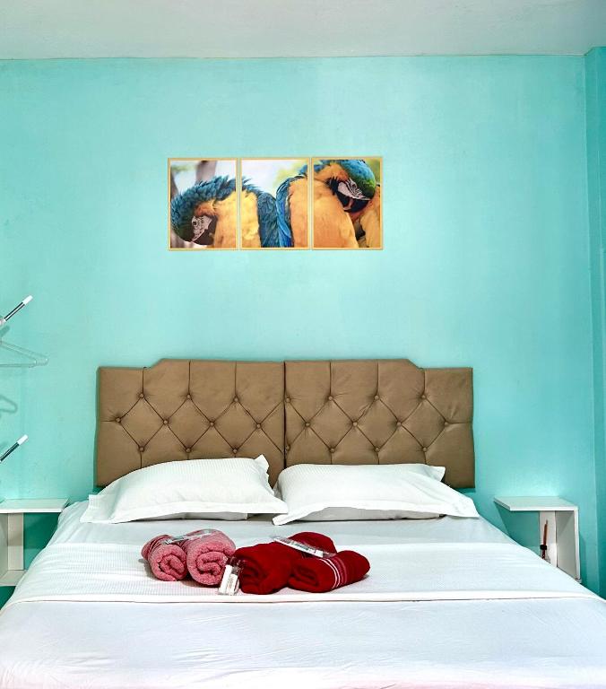 a bed with red roses on top of it at Suíte Verde in Campo Grande