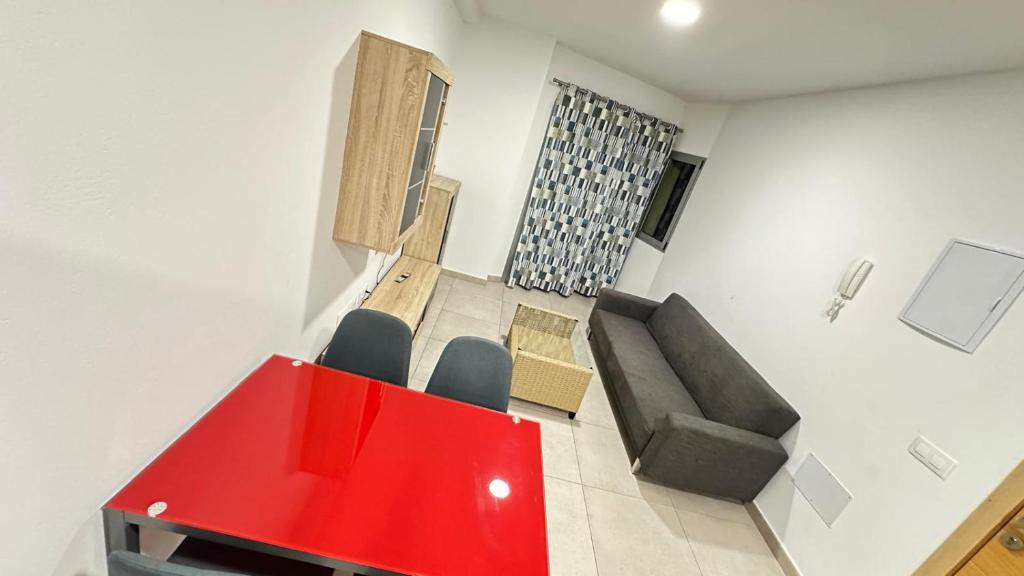 Una sala de estar con una mesa roja y un sofá. en Buena Vista, en Arinaga