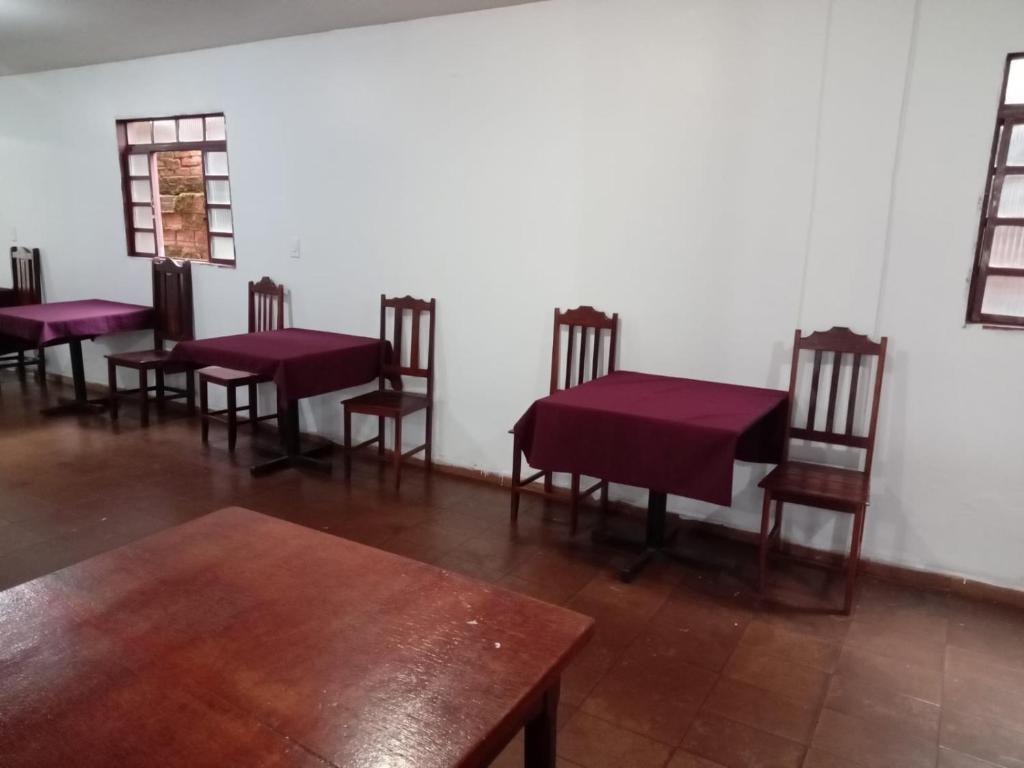 a group of tables and chairs in a room at Hotel paraiso in Jataí