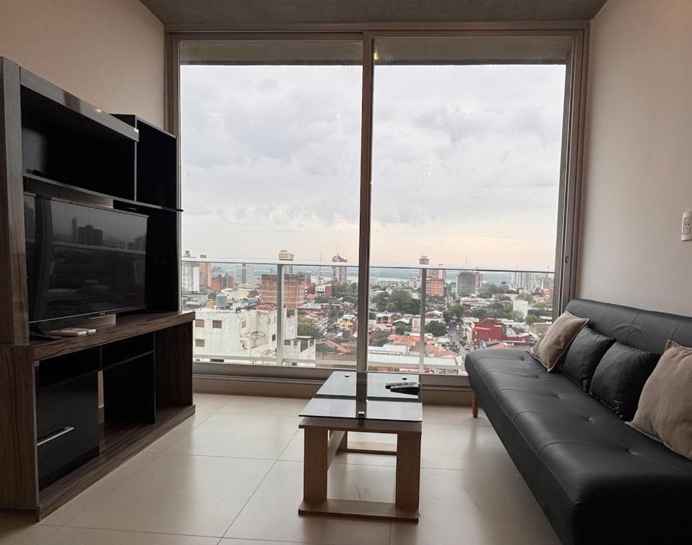 a living room with a couch and a large window at Central apartment in Asunción in Asuncion