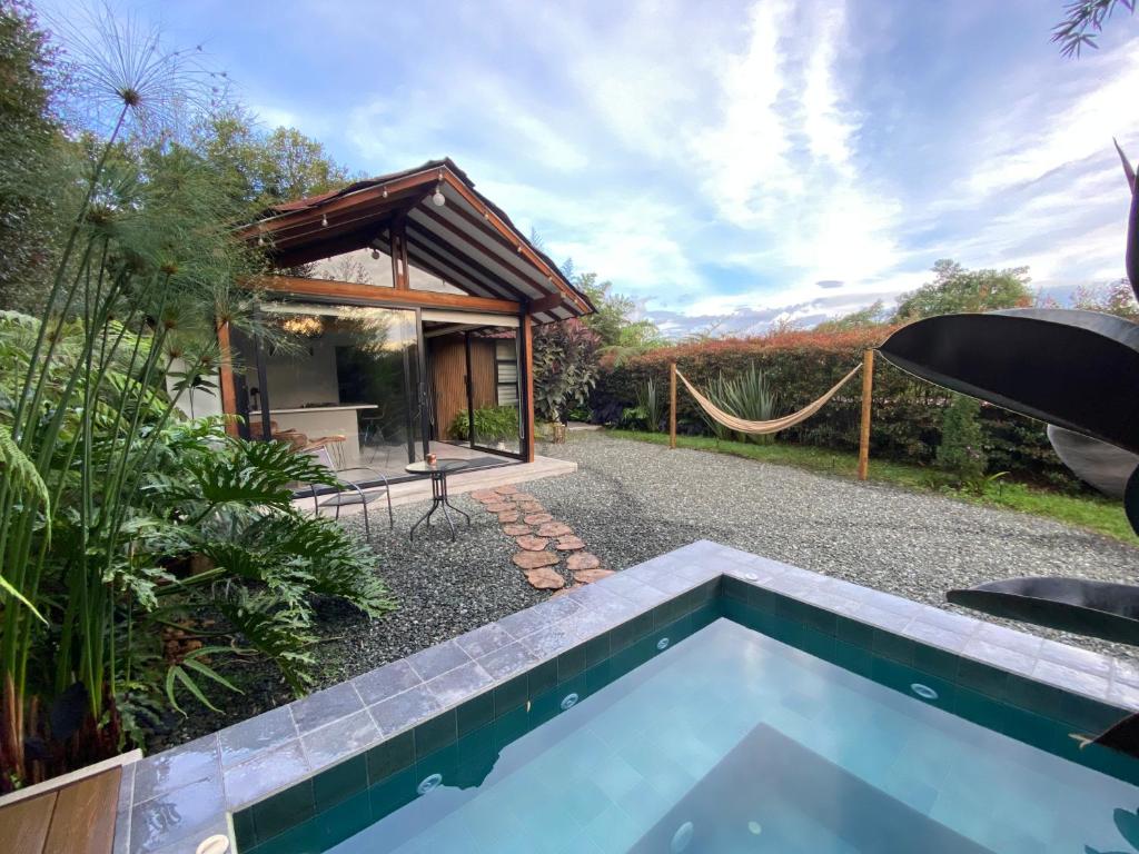 a villa with a pool and a hammock at Cabaña Lembos Jacuzzi con vista al cielo in Pereira