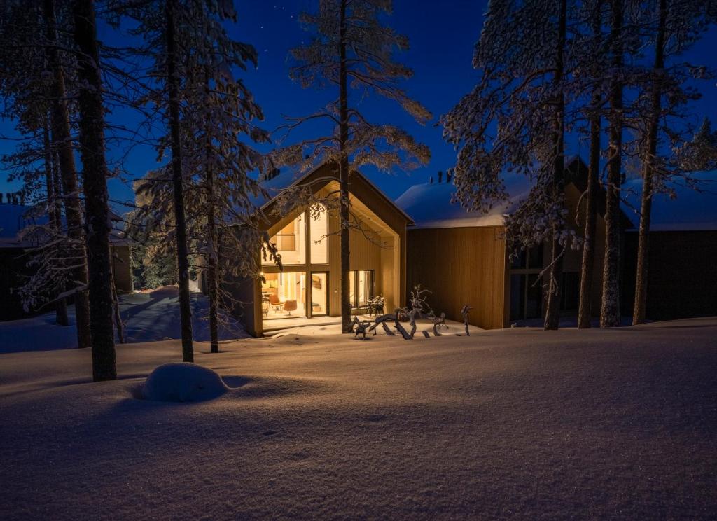 a house in the woods at night in the snow at Villa QUU A, Superior 4BD detached Villa in Äkäslompolo